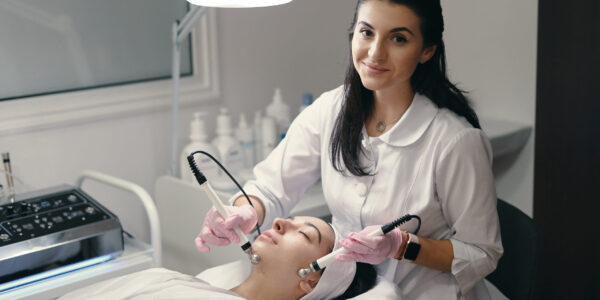 Rejuvenating facial treatment Model with closed eyes and hand's of doctor. Rejuvenating facial treatment. Model getting lifting therapy massage in a beauty SPA salon. Cosmetological clinic, procedure.