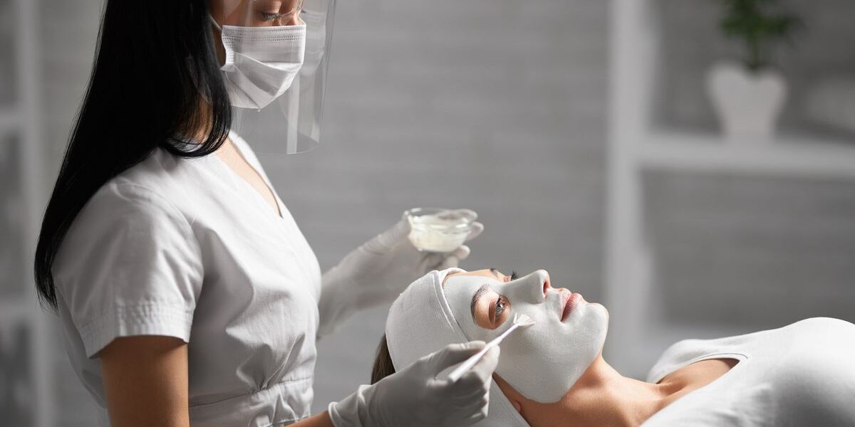 Student performing advanced facial aesthetics treatment during professional training session
