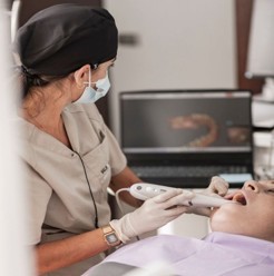 Dentist consulting with a patient in a modern cosmetic dentistry clinic during a smile makeover treatment session.