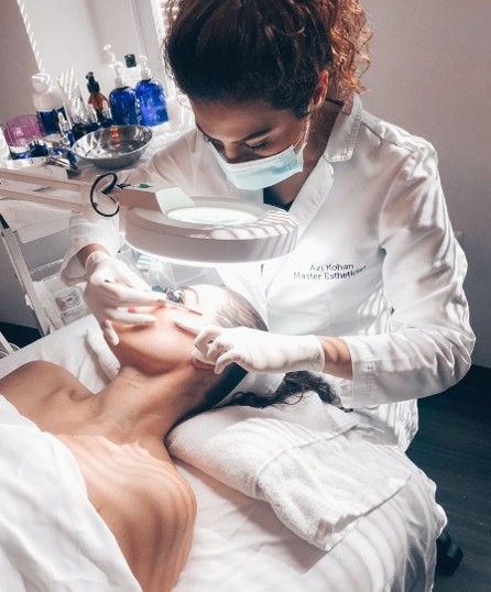 Aesthetic medicine doctor performing facial injectable treatment on a live patient under expert supervision during clinical training